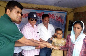 आपदा पीड़ितों को आर्थिक सहायता प्रदान करते समिति के सदस्य 